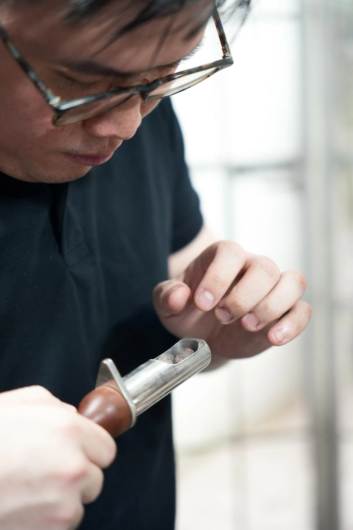 TYRONE CHUA checks a batch of roasted cacao beans.