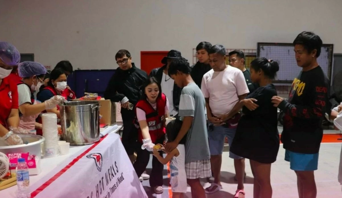 Mayor Charo Sy-Alvarado Mendoza hands food to a child evacuee. (Photo courtesy of Mayor Charo)