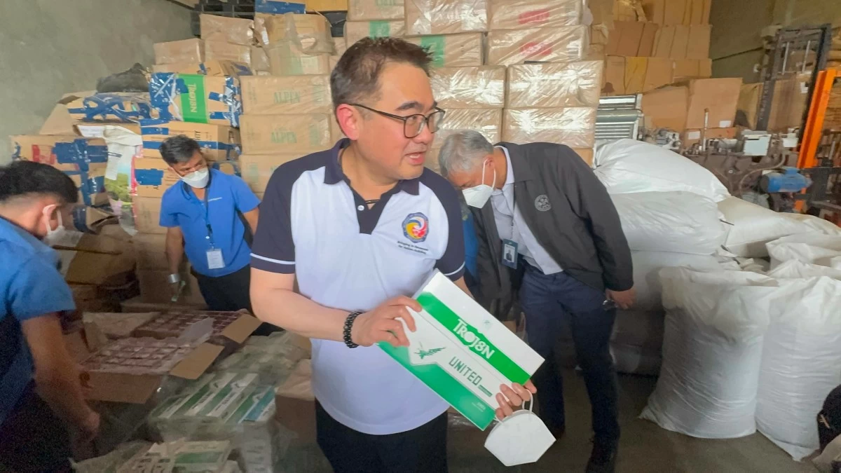 Finance Secretary Frederick D. Go inspects boxes of cigarettes during the destruction of illicit tobacco products and other items on Thursday, Aug. 13, in Mandaue City.(Photo via Calvin Cordova)

