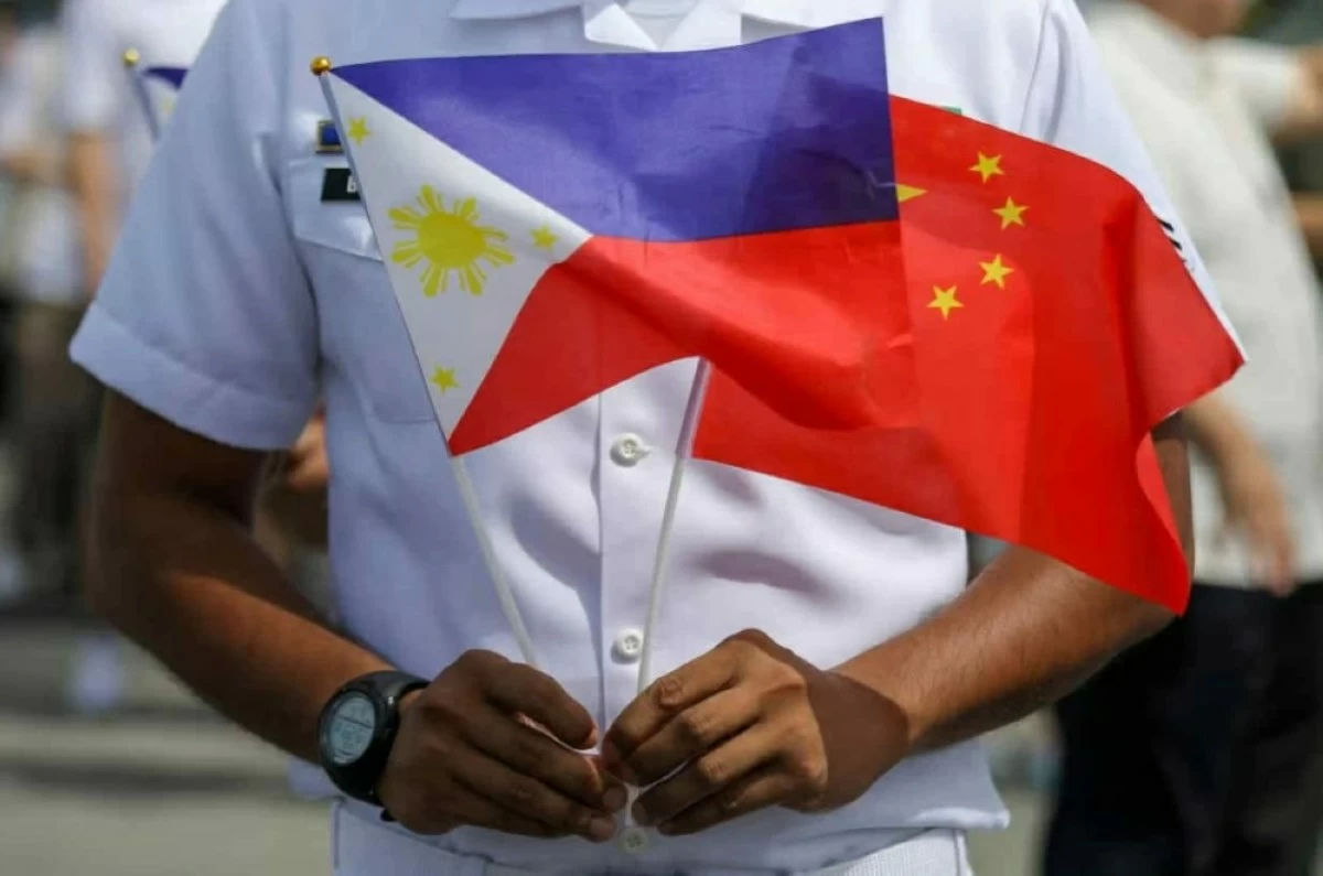 Filipino-Chinese Friendship Day is observed every June 9 to commemorate decades of diplomatic relations and people-to-people ties between the Philippines and China. The photo shows a man holding the flags of the Philippines and China. (AP photo)
