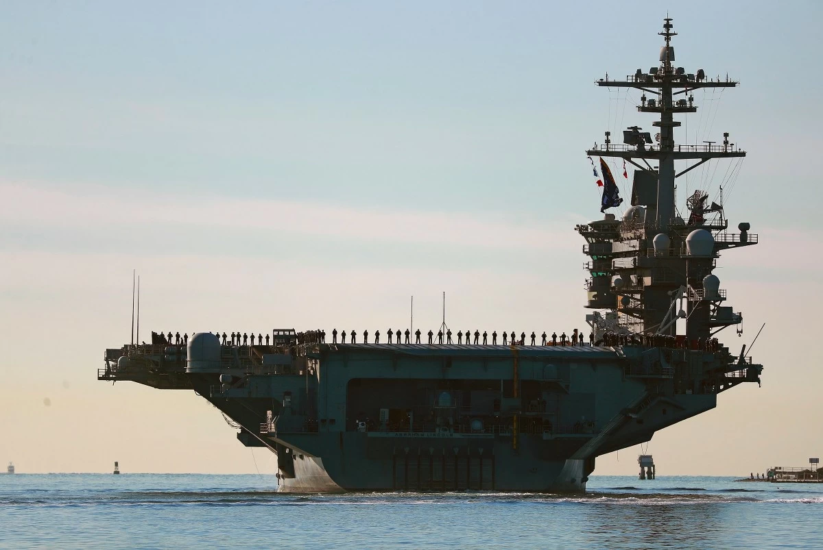 FILE - Sailors and Marines line the deck of aircraft carrier USS Abraham Lincoln (CVN-72) as it deploys from San Diego, Jan. 3, 2021. (K.C. Alfred/The San Diego Union-Tribune via AP, File)