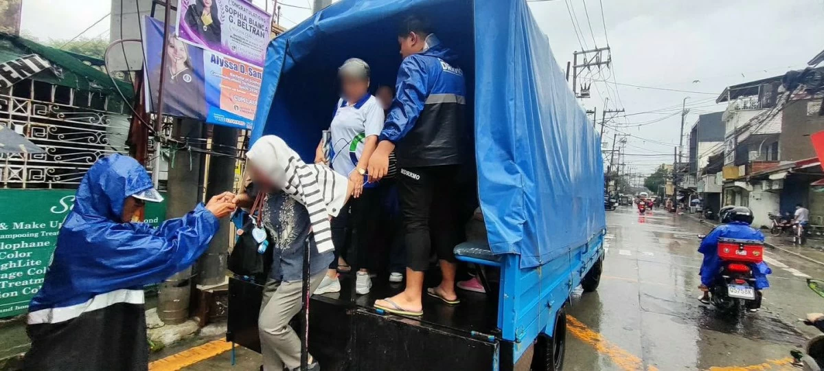 Authorities assist residents boarding “Libreng Sakay” trucks. (Photo from Malabon PIO)