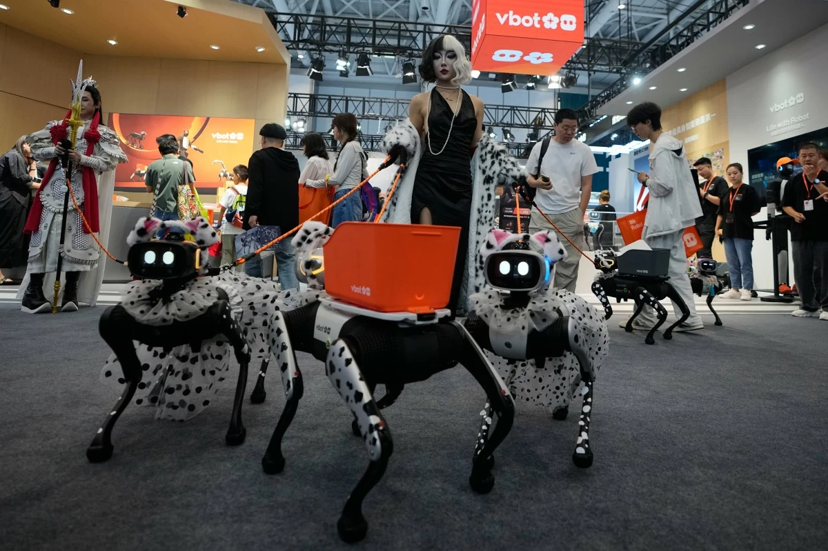 A model shows her fancy dressed up robotic dogs at a booth during the World Robot Conference at the Beiren Yichuang International Convention and Exhibition Centre in Beijing, Wednesday, Aug. 19, 2026. (AP Photo/Andy Wong)