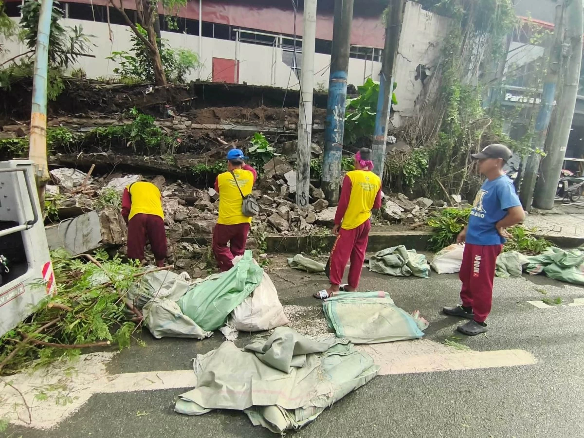 Personnel clear debris from a collapsed wall along Shaw Boulevard near Calderon Street in Mandaluyong City on Wednesday, Aug. 20. (Photos from Mandaluyong DRRMD)