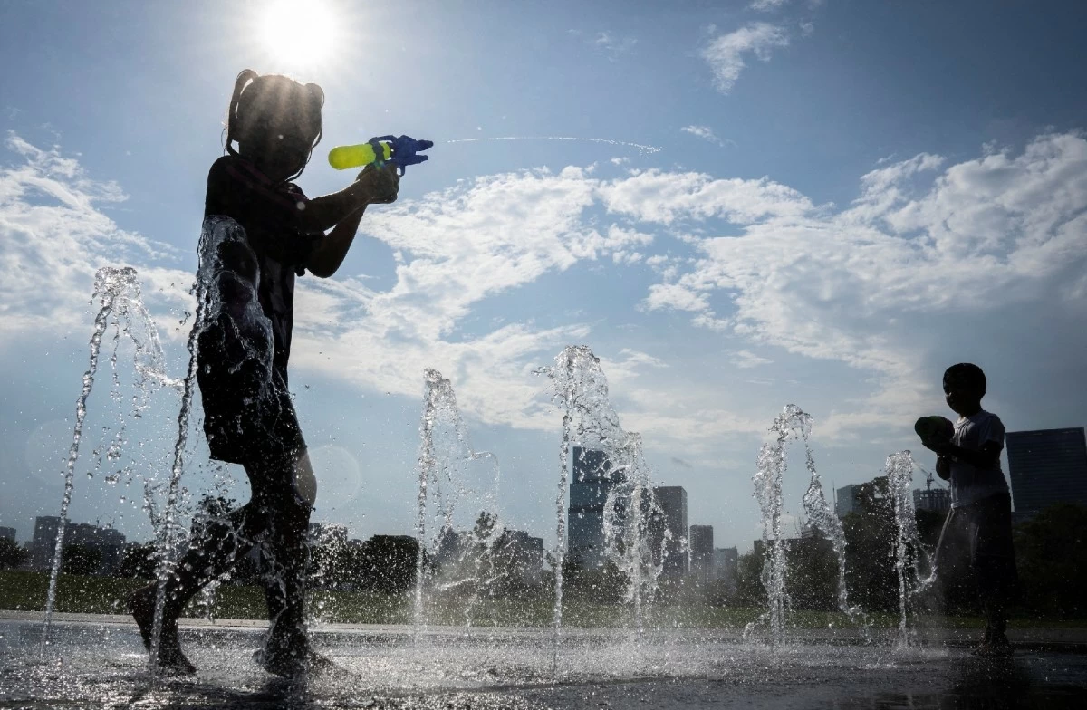 Children play in a public fountain and cool off from the summer heat in Japan.
