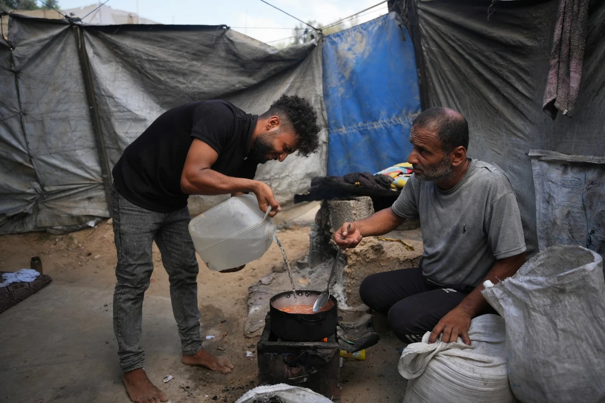 Palestinians use combustible materials collected from a garbage dump as fuel for cooking amid a shortage of cooking gas in Deir al-Balah, central Gaza Strip, Saturday, Aug. 22, 2026. (AP Photo/Abdel Kareem Hana)