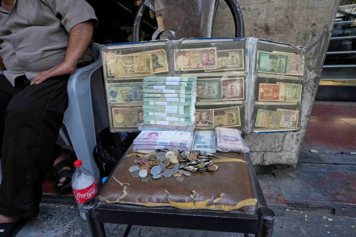 Current and pre-revolution Iranian banknotes are displayed by a street money exchanger at Ferdowsi square, a hub for foreign currency trading in downtown Tehran, Iran, Monday, Aug. 24, 2026. (AP Photo/Vahid Salemi)