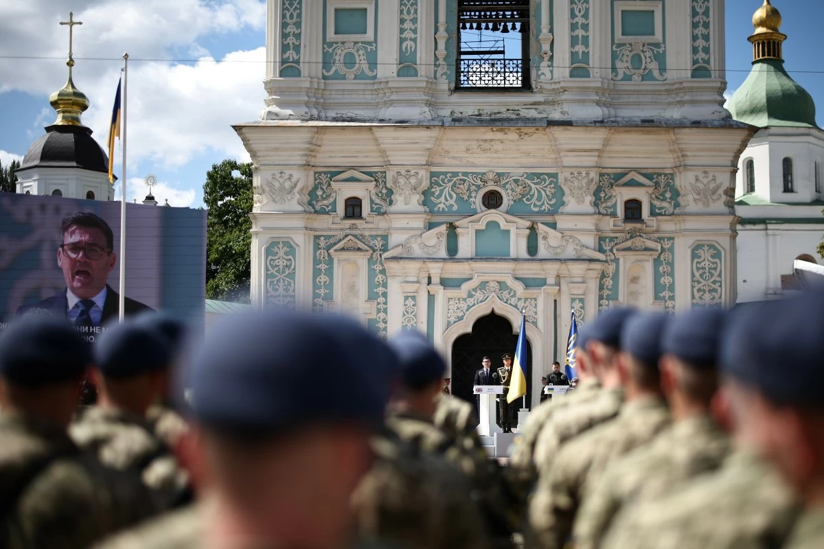 Britain's Prime Minister Andy Burnham, center, appears also on a giant screen, left, as National Guard of Ukraine and European leaders attend a commemorative ceremony marking Ukraine's 35th Independence Day outside St. Sofia Cathedral in Kyiv, Ukraine, Monday, Aug. 24, 2026. (Henry Nicholls/Pool Photo via AP)