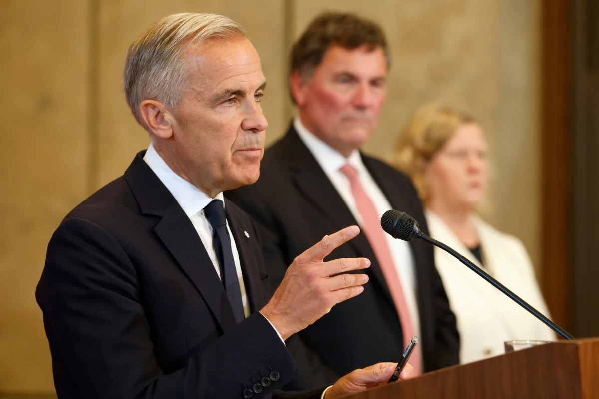 Canada-U.S. Trade Minister Dominic LeBlanc and chief trade negotiator Janice Charette listen as Prime Minister Mark Carney speaks about Canada's response to new U.S. tariffs during a news conference on Parliament Hill in Ottawa on Saturday, Aug. 22, 2026. (Patrick Doyle/The Canadian Press via AP)