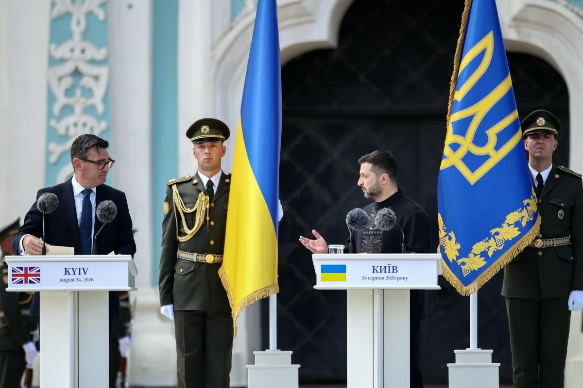 Britain's Prime Minister Andy Burnham, left, looks at Ukraine's President Volodymyr Zelensky delivering a speech during a commemorative ceremony marking Ukraine's 35th Independence Day outside St. Sofia cathedral in Kyiv, Ukraine, Monday, Aug. 24, 2026. (Henry Nicholls/Pool Photo via AP)