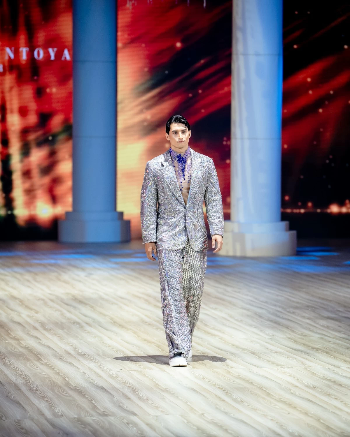 Crafted in an opalescent grey-lavender that shifts with iridescent rainbow hues, the suit is intricately embellished to evoke the cosmos that lives within each of us.