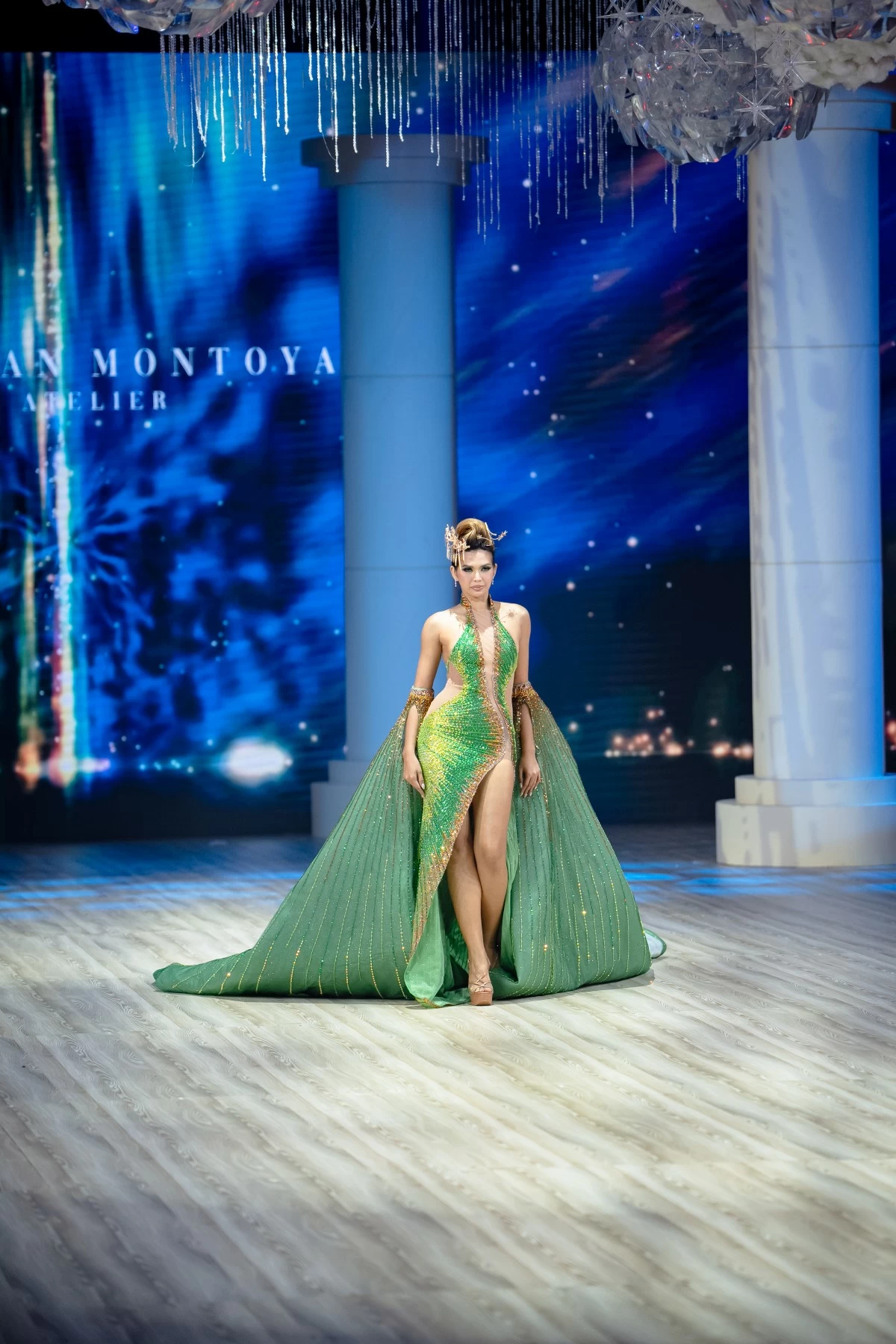 A halter serpentine gown with an asymmetric deep neckline flowing into a continuous slit, paired with a voluminous empress cape. 