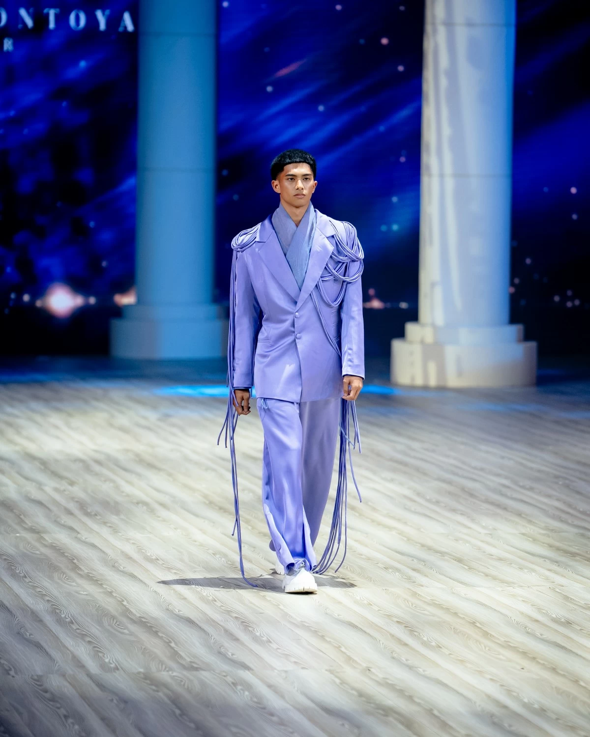 A periwinkle blue ensemble with asymmetrical fabric drapes.