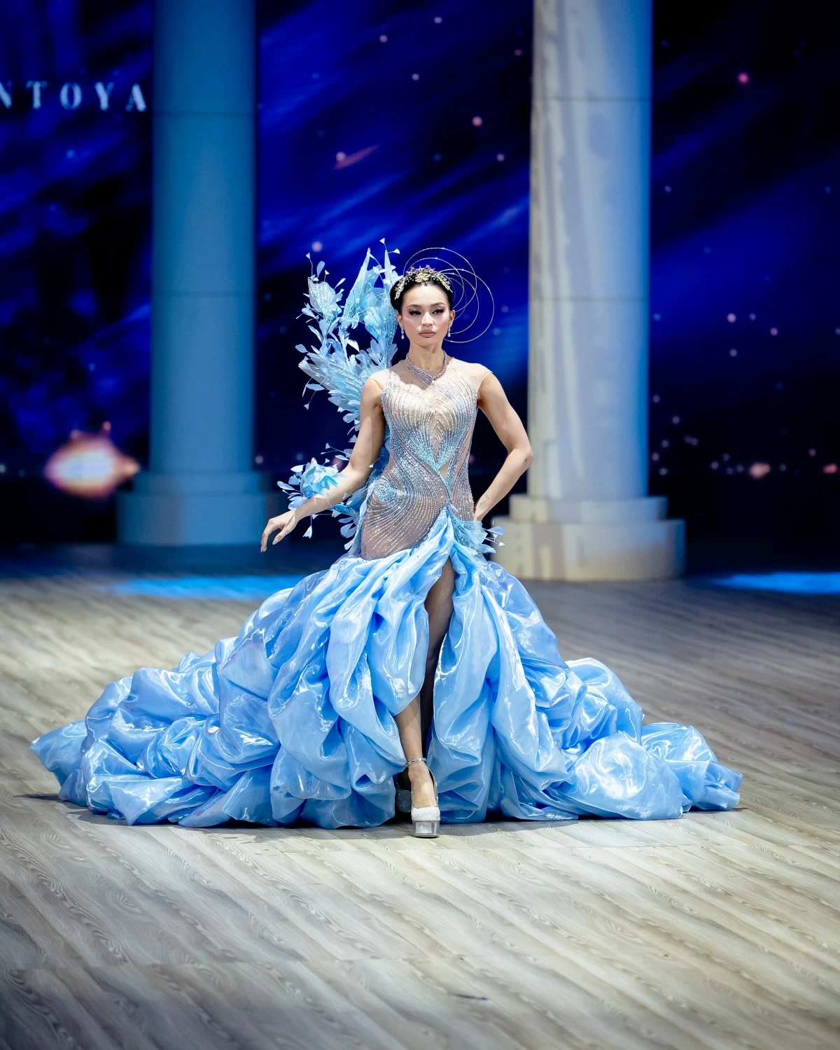 A pastel blue drop-waist ball gown with voluminous bubble layers in liquid jusi is adorned with intricate linear beadwork. 