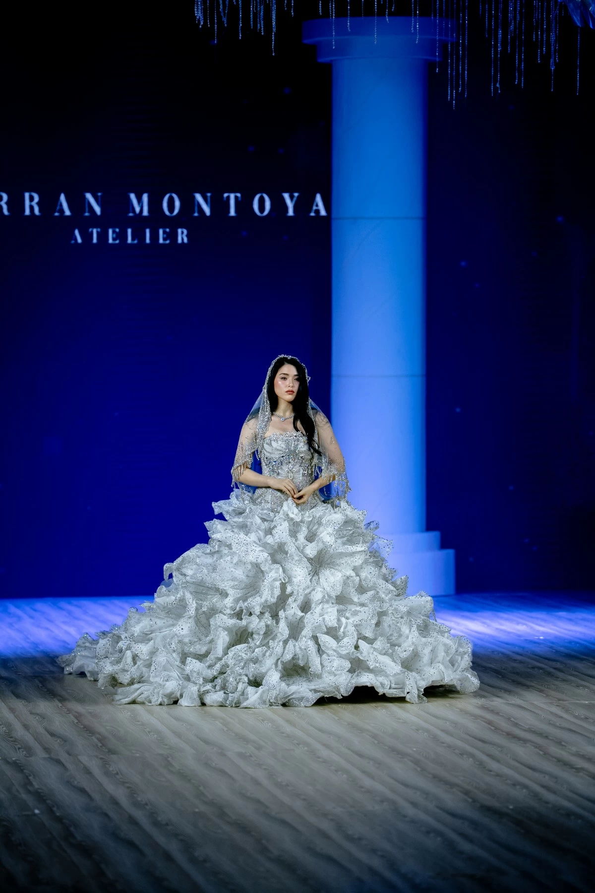  Embellished with silver crystals and cloaked in an intricately encrusted veil, this celestial drop-waist ball gown shines as the grand finale.