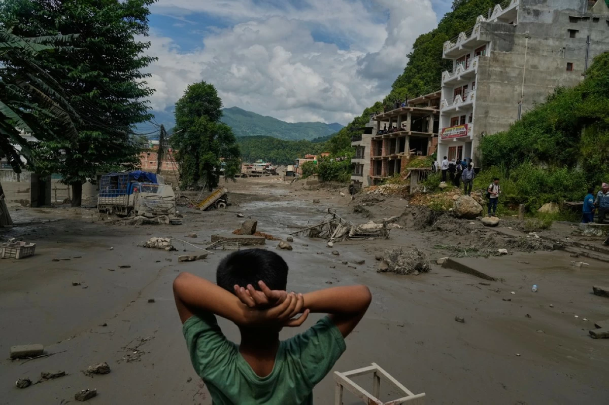 A boy looks at the devastation caused by flash flooding along the Trishuli River in Nepal's Nuwakot district, Wednesday, Aug. 26, 2026. (AP Photo/Niranjan Shrestha)