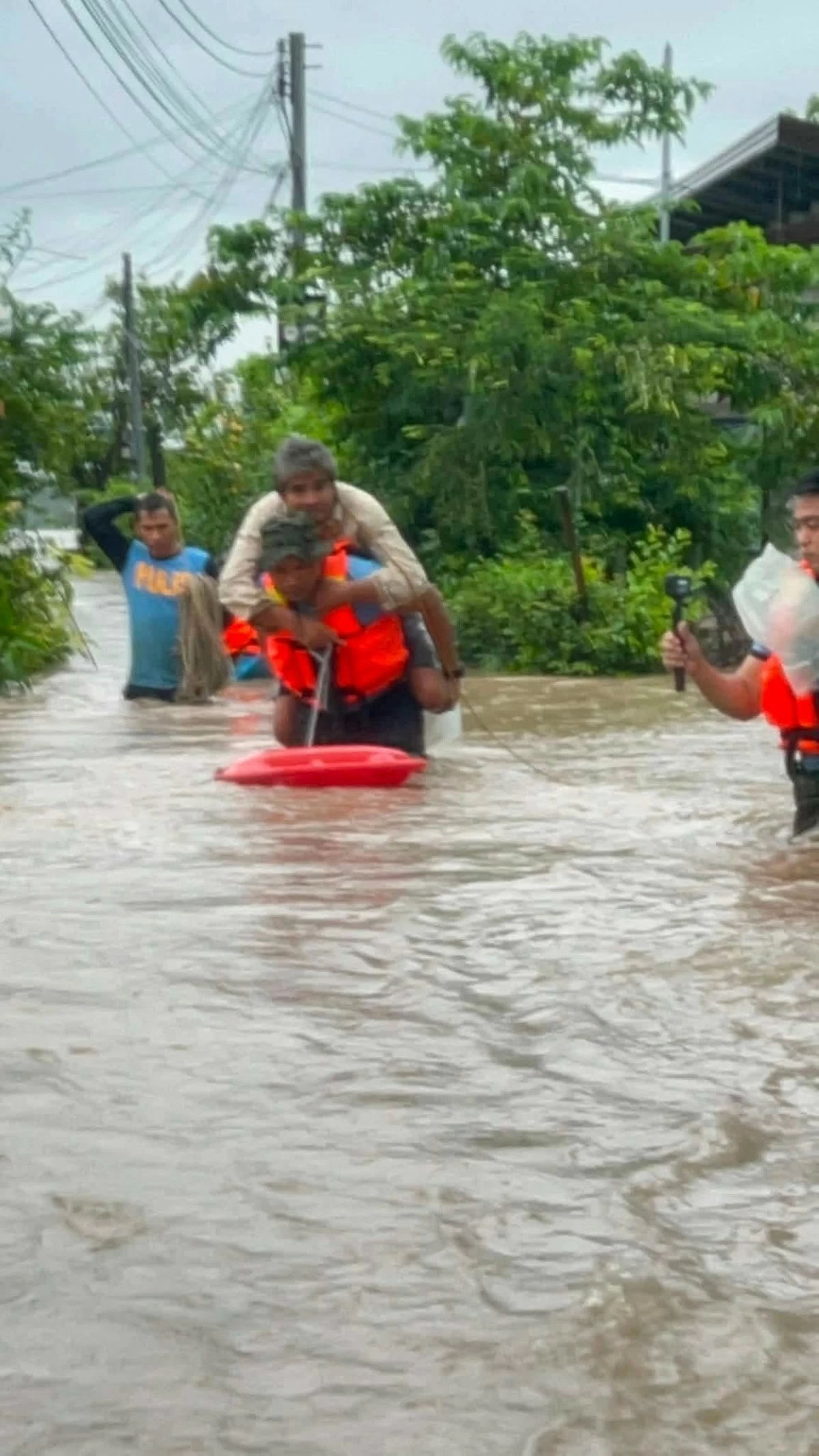 Pampanga police quickly responded to a call for help and rescued families affected by rapidly rising floodwaters in Barangay Sto. Cristo, Lubao, Pampanga on Friday. (Photo courtesy of PNP / via Liezle Inigo)