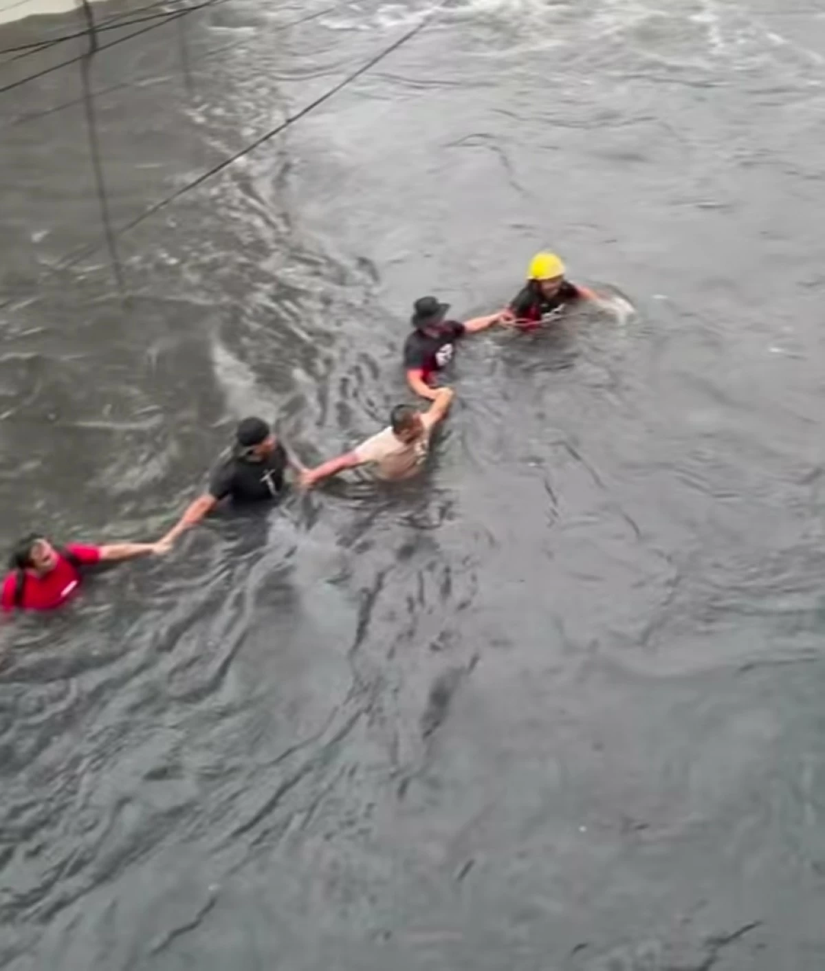Residents form a human chain to help rescuers bring four children to safety at Paso de Blas Bridge in Valenzuela City on Saturday, Aug. 29. (Screengrab from Leng Deocareza/Facebook)