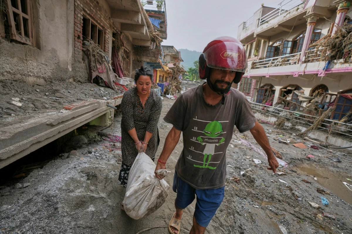 Residents salvage their belongings from damaged houses after flash flooding in the Devighat area of Nuwakot district in Nepal, Friday, Aug. 28, 2026. (AP Photo/Rajesh Kumar Singh)