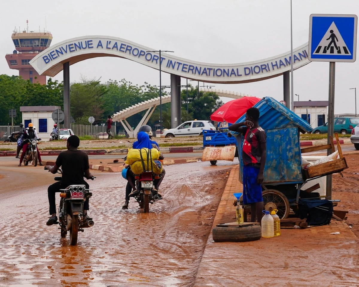 FILE - Motorcyclists ride by the entrance of the airport in Niamey, Niger, Aug. 8, 2023. (AP Photo/Sam Mednick, File)