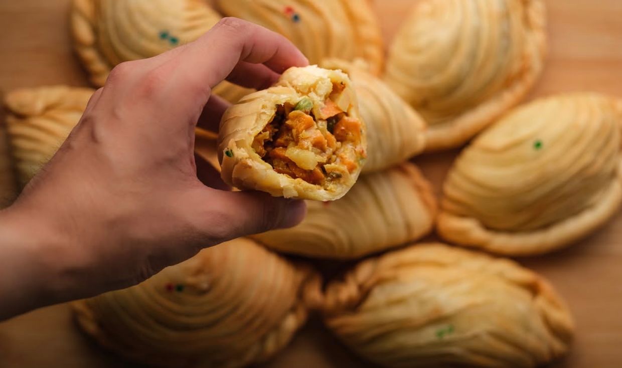 EMPANADA KALISKIS A petite, crispy empanada filled with ground pork and beef, cheese, and raisins.jpg