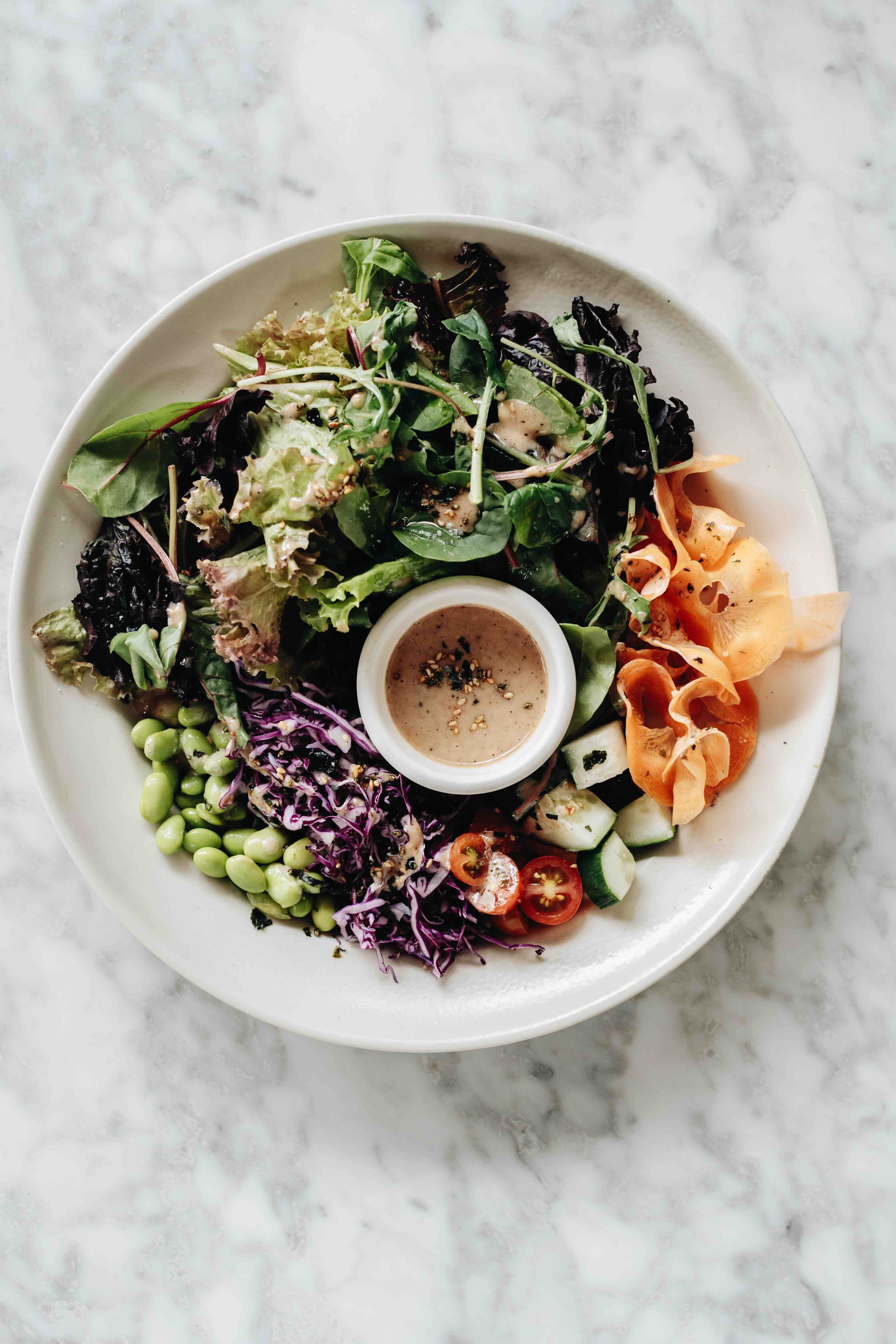 FARMER'S SALAD Shredded carrot, red cabbage, cucumber, cherry tomatoes, and edamame—all tossed in a roasted sesame dressing with a Japanese nod.jpeg