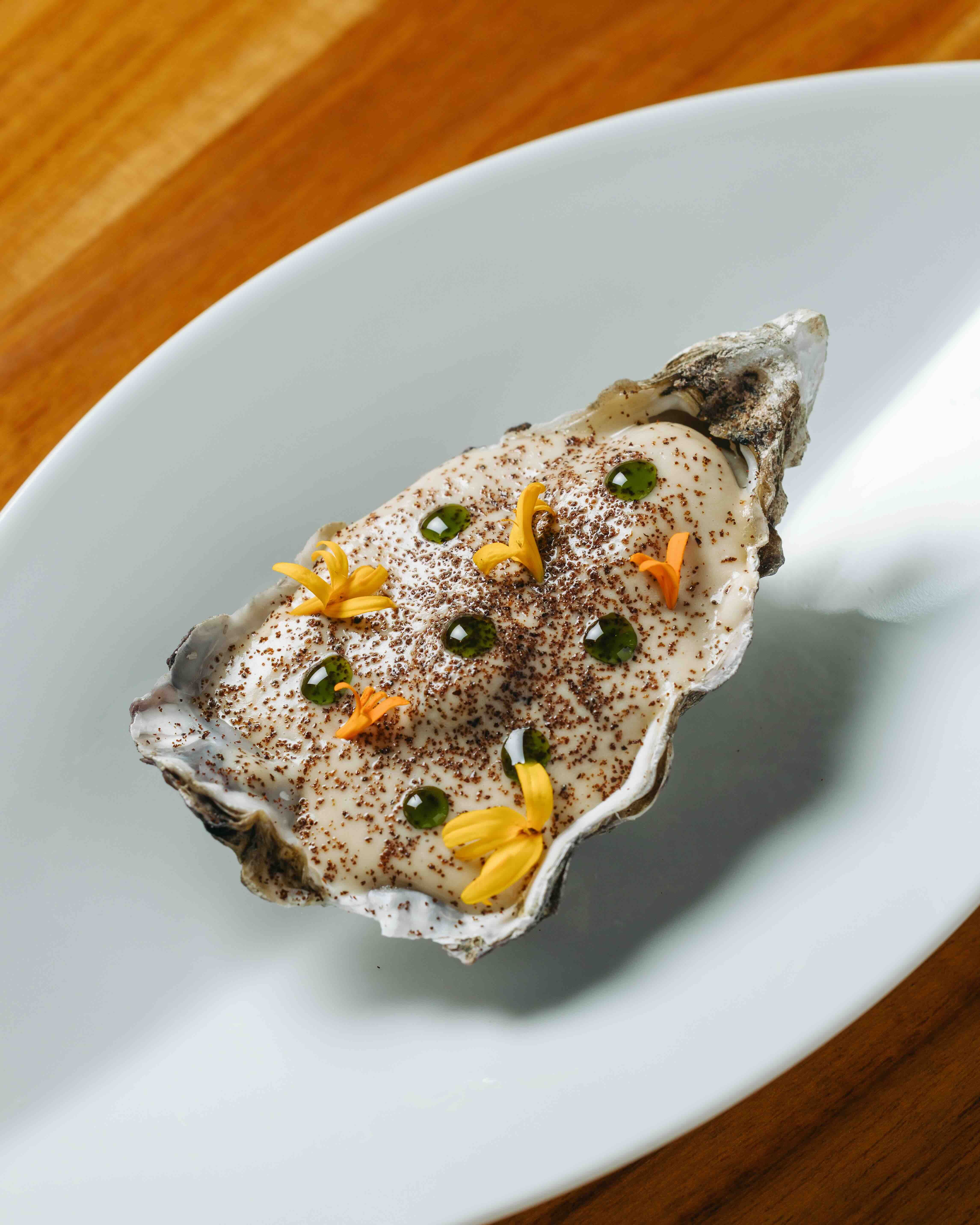 OYSTER Topped with caramelized topinambour or Jerusalem artichoke and pickled pineapple.jpeg