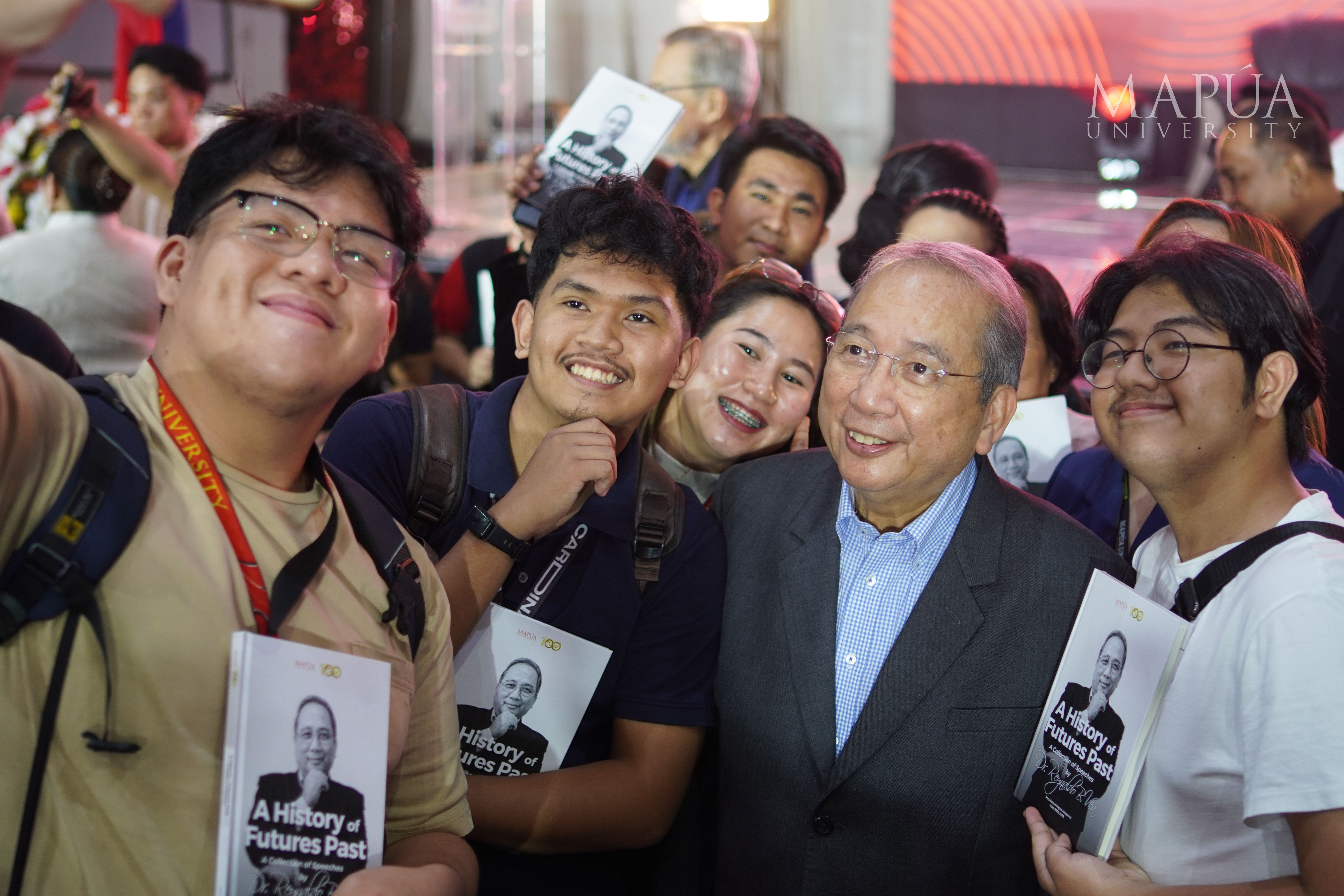 The Mapúa community smile warmly for the camera beside the author of the book in their possession.jpg